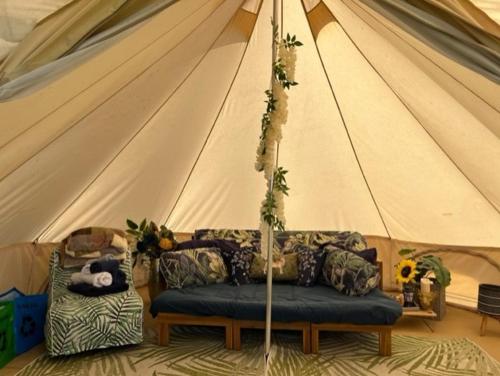 a living room with a couch in a tent at Betrice Bell Tent in Poulton le Fylde