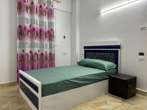a bedroom with a bed with a purple curtain at مبيت Mabeet - شقق ستديو in 6th Of October