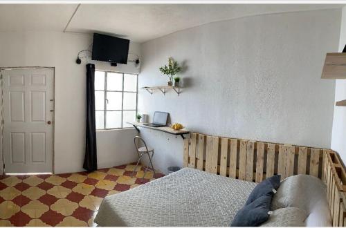 a bedroom with a bed and a window and a door at Urban Hotel in Guatemala