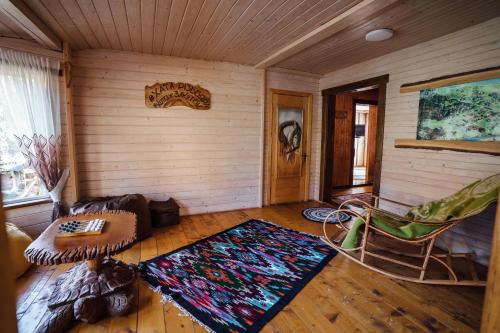 a living room with a couch and a chair at Хата Різьбяра - Закуток in Beloberëzka