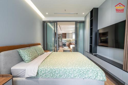 1 dormitorio con 1 cama y TV de pantalla plana en Merry House Harmony, en Ðông Khê