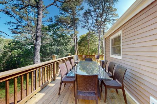 a wooden deck with a table and chairs on it at Old Kings Hideout in Wellfleet