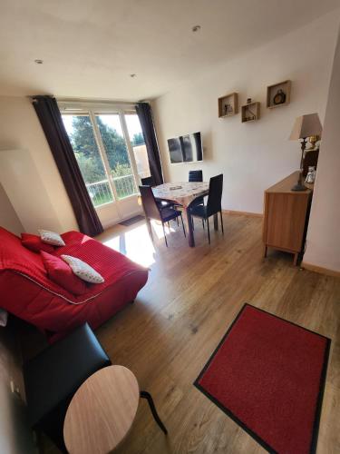 un salon avec un canapé rouge et une table dans l'établissement Appartement T2 entièrement rénové dans résidence calme, à Font-Romeu-Odeillo-Via