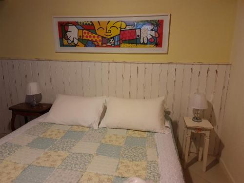 sypialnia z łóżkiem z dwoma stołami i obrazem w obiekcie POUSADA NICO ON THE HILL w mieście Monte Verde