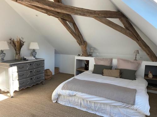 a bedroom with a large bed and a dresser at maison 8 pers avec piscine en pleine nature in Ambenay