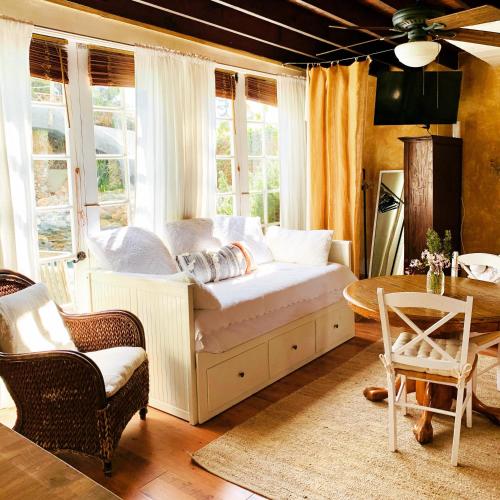 a room with a bed and a table and windows at Under the Tuscan Sun Cottage in West Los Angeles in Los Angeles