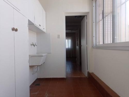 Un baño blanco con lavabo y espejo. en Amplio Departamento Céntrico, en San Juan