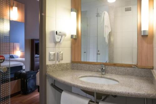 y baño con lavabo y espejo. en ibis Santiago Las Condes Manquehue en Santiago