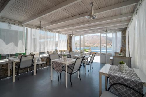 un restaurante con mesas y sillas y una gran ventana en Astrio Suites en Livadi