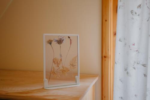 a picture of flowers in a glass container on a table at Widokówka Kaszuby in Mirachowo