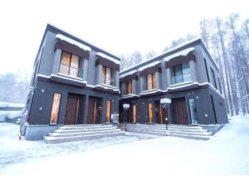 uma casa com neve no quintal em Ｑｕｅｅｎｓ Ｐａｒｋ ＣＫ ＶＩＬＬＡＧＥ Ｎｉｓｅｋｏ Ｈｉｒａｆｕ Ｉ - Vacation STAY 14145 em Niseko