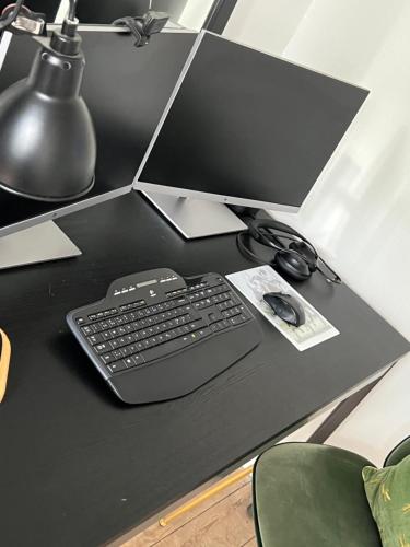 a computer keyboard and mouse on a black desk at KøbenhavnK in Copenhagen