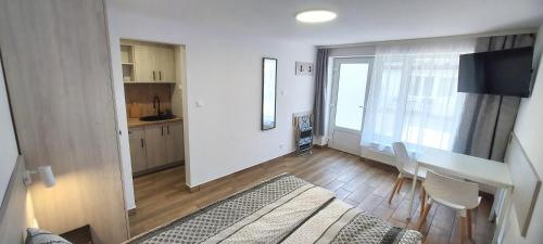1 dormitorio con 1 cama y cocina con ventana en Nawigator Apartamenty - Dźwirzyno, en Dźwirzyno