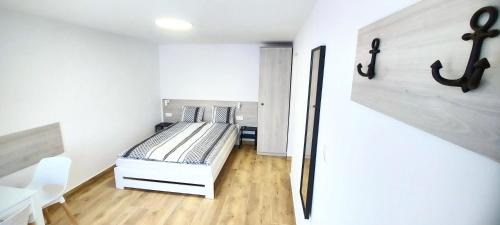 um pequeno quarto com uma cama num quarto em Nawigator Apartamenty - Dźwirzyno em Dźwirzyno