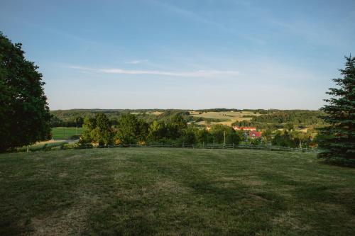 a large grassy field with trees in the background at Widokówka Kaszuby in Mirachowo