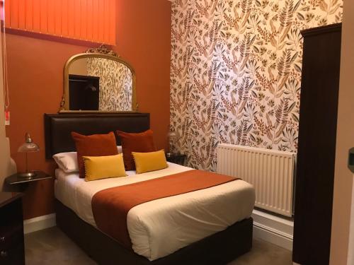 a bedroom with a bed with orange and yellow pillows at The Exhibition in York