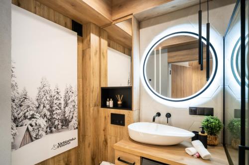 a bathroom with a sink and a mirror at Apartament Niebiańska Polana by Apart Concept Podhale in Kościelisko