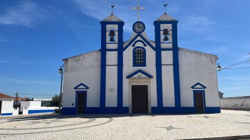 a blue and white church with a clock tower at Casa Pardalitos in Alandroal