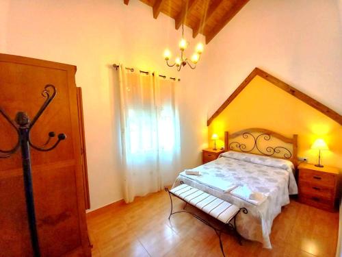 1 dormitorio con cama y banco. en Casas Rurales Venta Ticiano, en El Morrion