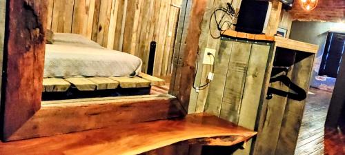 a bedroom with a bed in a wooden room at Hocking Hills Rusty Lofts in Logan