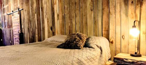 a bed in a room with a wooden wall at Hocking Hills Rusty Lofts in Logan