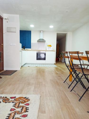 a kitchen with blue cabinets and a table and chairs at Vistas a las palmeras in Burjassot