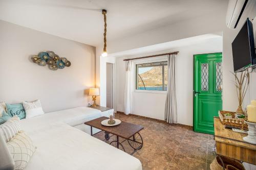 sala de estar con sofá blanco y puerta verde en Astrio Suites, en Livadion