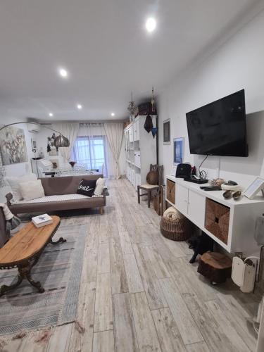 a living room with a couch and a tv at Casa Esti in Olhão