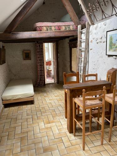 une chambre avec une table, des chaises et un lit superposé dans l'établissement La Maison du meunier, à Romorantin-Lanthenay