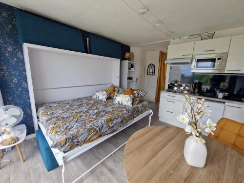 une chambre avec un lit et une cuisine dans l'établissement GUIDEL-PLAGES Studio Lumineux Balcon Vue Mer & Piscine, à Guidel