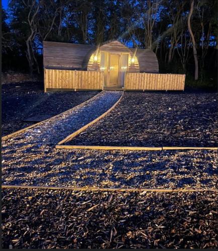 a house with lights on a gravel driveway at night at Cliff Stud Retreat - Luxury lodges and cosy cottages in Helmsley