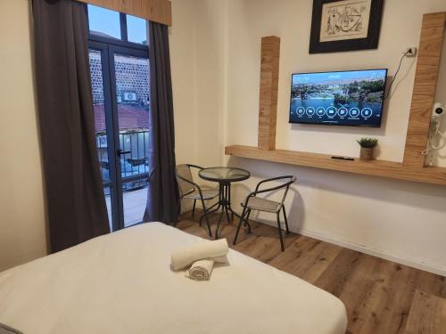 Habitación con cama, mesa y ventana en מלון טיבריא, en Tiberíades