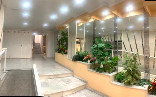 a hallway of a building with many plants at ApartalMar in Torrevieja