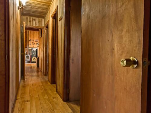 a hallway with wooden floors and an open door at Casa Vacacional Panguipulli in Panguipulli