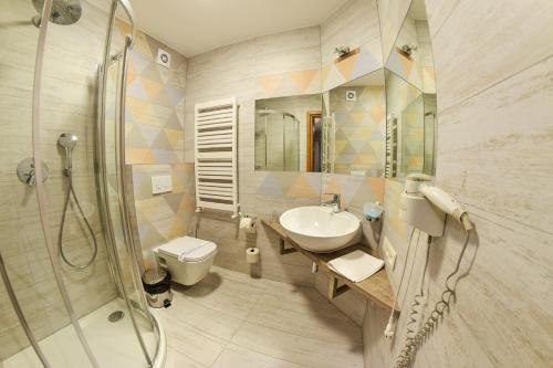 a bathroom with a sink and a toilet and a shower at Hotel Panorama Nowy Sącz in Nowy Sącz