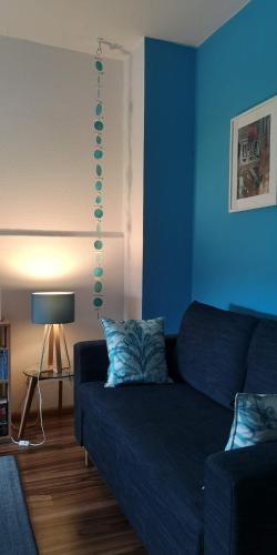 a blue living room with a couch and a lamp at Ninas B&B - exklusiv für Frauen in Bremen