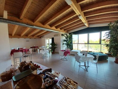 a living room with wooden ceilings and tables and chairs at Hotel Spazio Residenza in Pescara