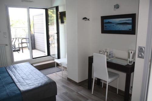 a bedroom with a desk and a bed and a table at MOR-HA-MARCH Chambres d'Hôtes in Sarzeau