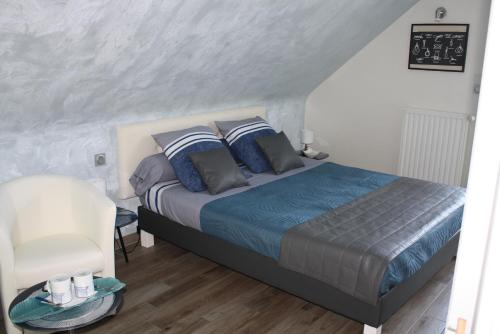 a bedroom with a bed and a chair at MOR-HA-MARCH Chambres d'Hôtes in Sarzeau