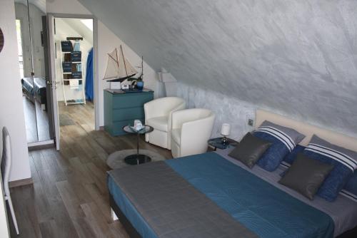 a bedroom with a blue bed and a chair at MOR-HA-MARCH Chambres d'Hôtes in Sarzeau