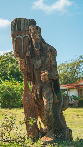 a statue of a man holding a basket at Cabañas MANA NUI INN in Hanga Roa