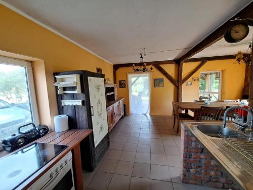 a kitchen with a refrigerator and a table in it at Śródziemie Gondor in Leśno