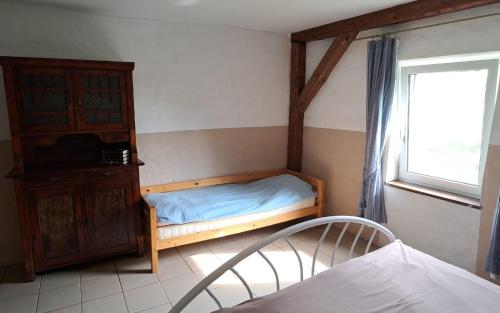 a bedroom with a bed and a dresser and a window at Śródziemie Gondor in Leśno