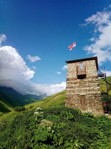a building with a flag on top of a hill at Hotel Veshagi in Jut'a
