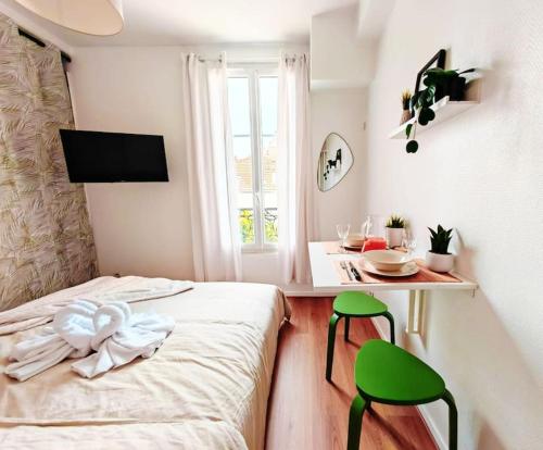 1 dormitorio con 1 cama, 1 mesa y 2 sillas verdes en L'Escale aux portes de Paris, en Charenton-le-Pont