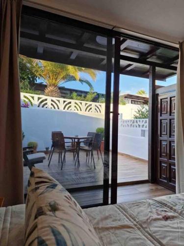 a bedroom with a view of a patio with a table at Apartamento Los Marinos in Tías