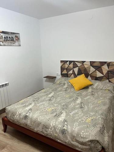 a bedroom with a bed with a yellow pillow at Cal Josep del Moto - Castelló de Farfanya in Castelló de Farfaña
