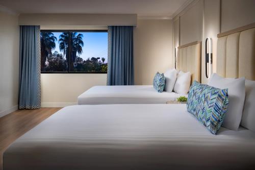 a hotel room with two beds and a window at The Anza-a Calabasas Hotel in Calabasas