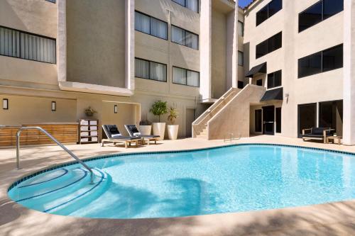 a swimming pool in the courtyard of a building at The Anza-a Calabasas Hotel in Calabasas