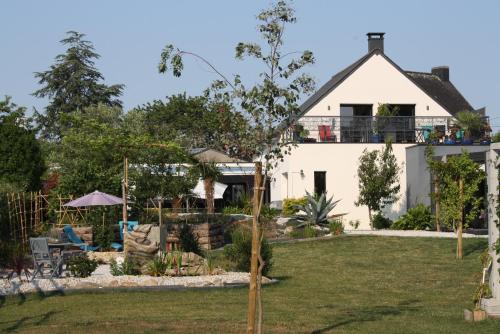 a white house with a balcony on top of a yard at MOR-HA-MARCH Chambres d'Hôtes in Sarzeau